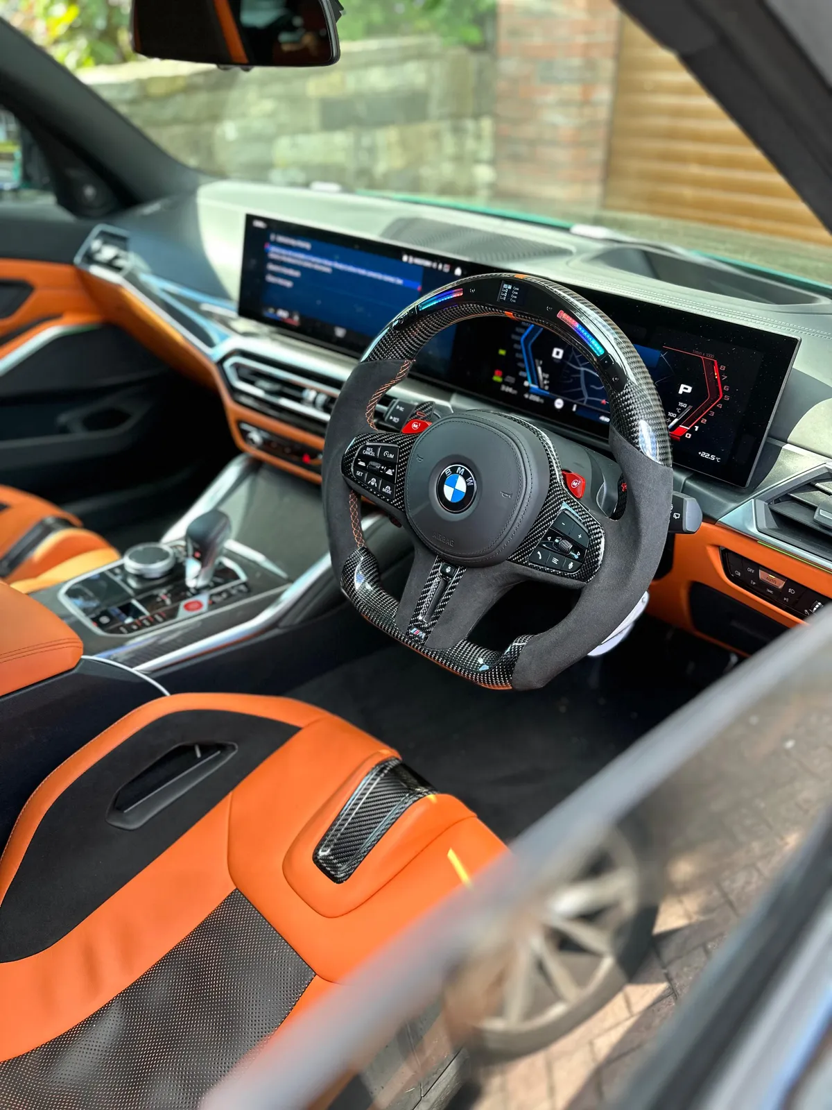 Carbon and Alcantara BMW M steering wheel with an RGB shift display in an M car.
